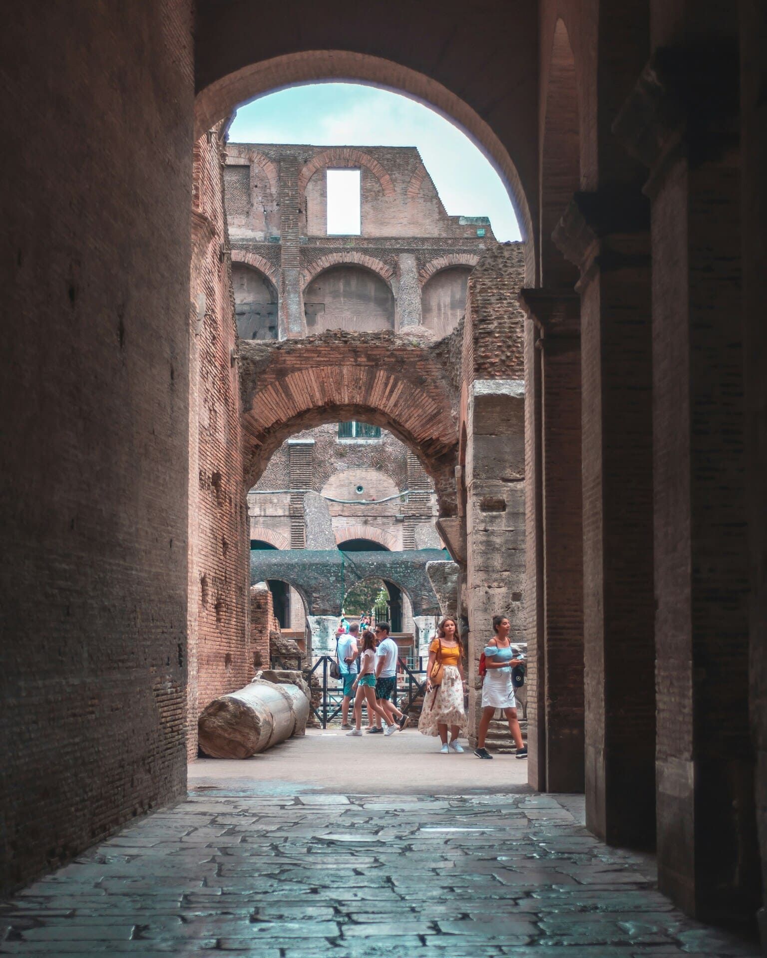 Scorcio di una galleria interna del Colosseo di Roma in cui si vedono dei visitatori in lontananza.